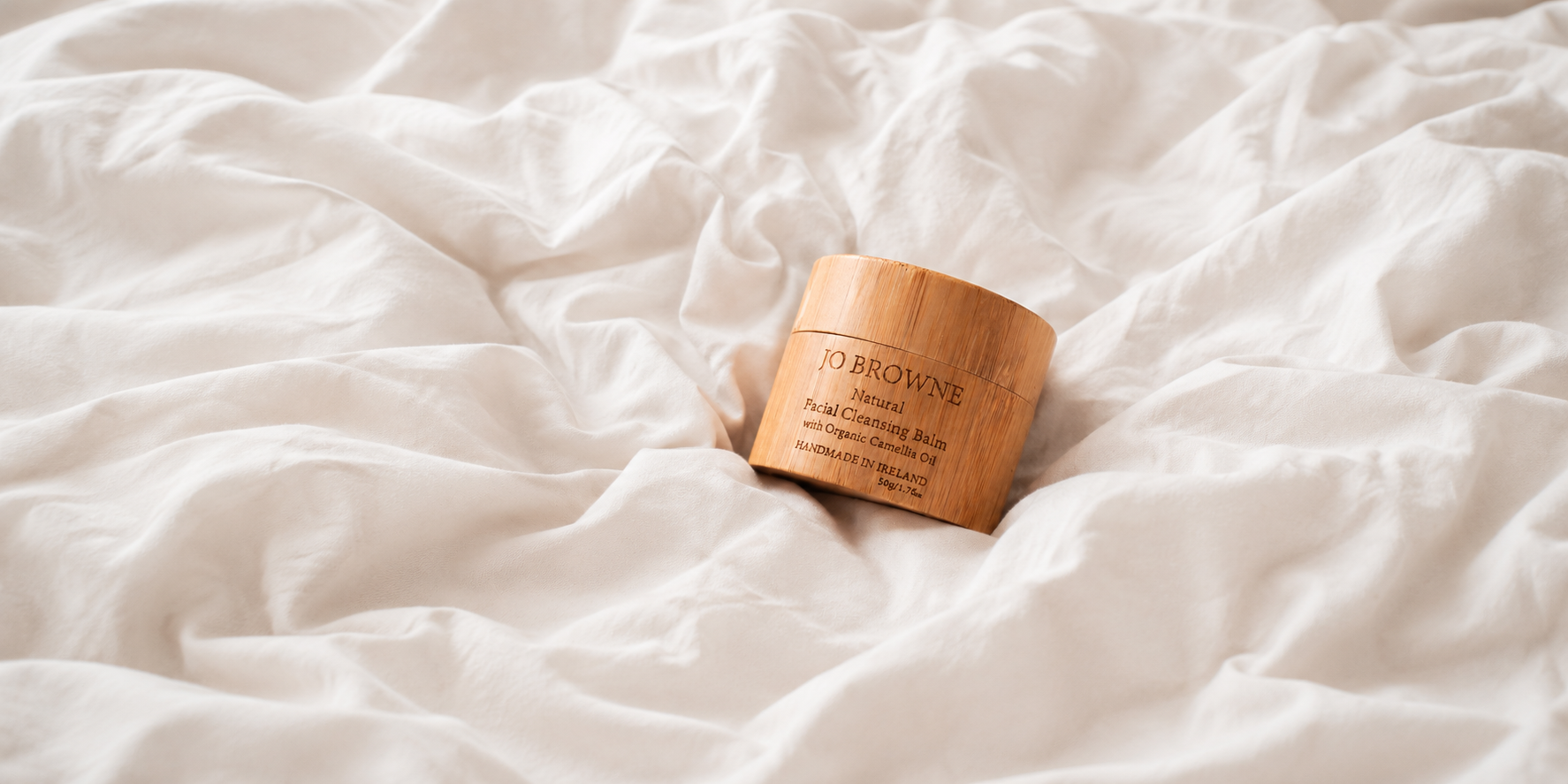Wooden jar with a label on a white textured surface